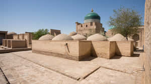 庭院內有磚砌圓頂和綠色瓷磚圓頂，在明亮的陽光下。 — 石頭 壁紙