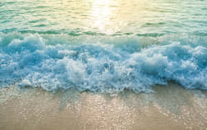 海浪拍打沙灘，陽光在水面上反射。 — 2880x1800 壁紙