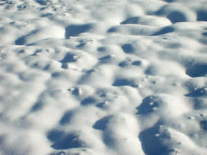 陽光照耀的雪堆在冬季投下深藍色陰影的特寫。 — 4:3 壁紙