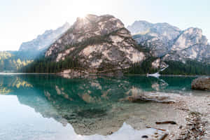 阿爾卑斯山倒映在綠松石色湖泊中，陽光穿透山峰。 — 湖泊 壁紙