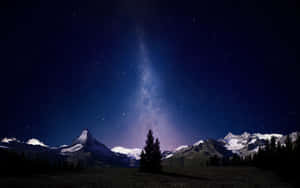在繁星點點的夜空下，雪山山脈，銀河可見 — OLED 壁紙