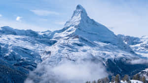 積雪的馬特洪峰山峰在清澈藍天的雲層之上聳立。 — 雪山 壁紙