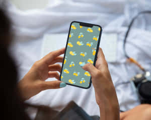 在床上拿著有檸檬壁紙手機的人 — 紅色美學 iPhone 壁紙