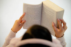一個人用手捧著打開的書頁在閱讀。 — 看書 GIF 壁紙