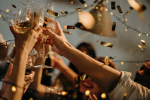 朋友們舉起酒杯碰杯，金色紙屑在他們周圍飄落。 — 慶祝 壁紙