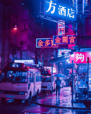 撐傘的人在雨夜霓虹燈照亮的城市街道上行走。 — 日式審美桌面 壁紙