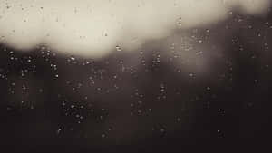 玻璃窗上的雨滴，背後有模糊的灰色天空和黑暗的景色。 — 美學圖案動畫 壁紙