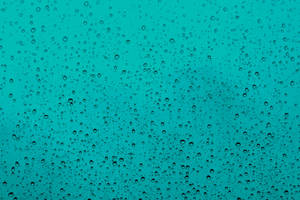 透過濺滿雨水的玻璃看到的青綠色天空 — 下雨 壁紙