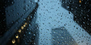 窗戶上的雨滴，映出模糊的城市燈光和夜晚的建築物。 — 美麗的秋天 壁紙