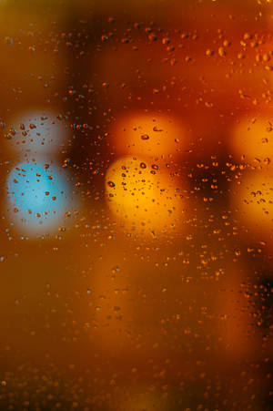 窗戶上的雨滴，背景是模糊的城市燈光。 — 焦點 壁紙