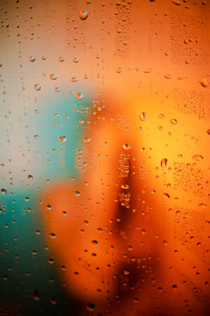 黃昏時窗戶上的雨滴，模糊的橙色和藍綠色城市燈光。 — 小米平板 7 Ultra 壁紙