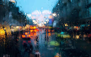 雨痕將夜間汽車玻璃上的城市燈光模糊。 — 下雨 壁紙