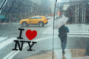 透過車窗看到的雨中城市景象，帶有 I heart NY 貼紙和黃色計程車。 — 紐約市 壁紙