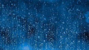 雨滴在藍色背景的玻璃表面上滑落。 — 下雨 壁紙