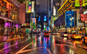 時代廣場的雨夜，霓虹燈光反射在濕漉漉的街道和黃色的士上。 — 紐約洋基 壁紙