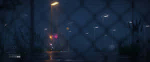雨夜的都市街道，透過鐵絲網圍欄觀看，帶有發光的街燈。 — 動漫風景美圖 壁紙