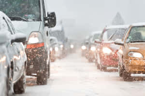 冬季風暴期間，汽車在積雪交通中塞車，車頭燈亮著。 — 冬季風景 壁紙