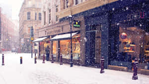 雪落在有燈光店鋪和行人的城市街道上。 — 冬季風景 壁紙