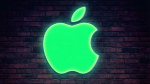 夜間深色磚牆上發光的綠色Apple標誌。 — 品牌 壁紙