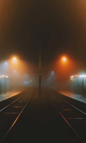 夜晚空無一人的火車站，有霧和發光的街燈。 — Infinix Xpad 20 Pro 壁紙
