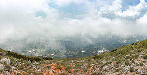 霧氣瀰漫的山景，雲霧飄過山峰，岩石前景。 — 蘇菲亞·維加拉 壁紙