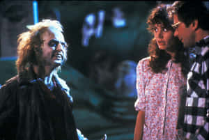 Beetlejuice在昏暗場景中與一男一女對峙。 — 陰間大法師 壁紙