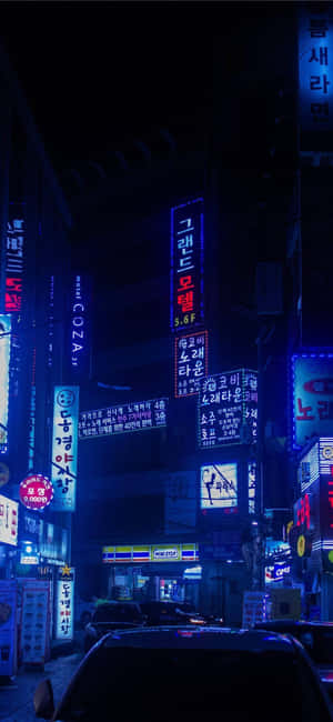 霓虹招牌照亮夜晚潮濕的城市小巷和停泊的汽車。 — iPhone 18 Pro Max 壁紙