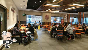 人們在漢堡王用餐，窗外可見積雪。 — 漢堡王 壁紙
