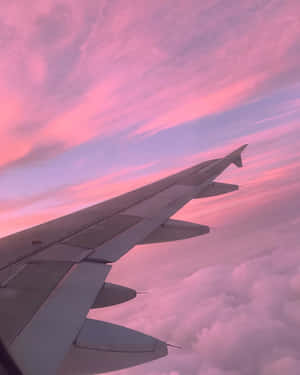飛機機翼在日落時飛越粉紅色的雲層 — 太空船 壁紙