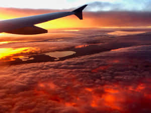 飛機機翼在雲層之上，閃爍著夕陽的色彩，照耀著大地。 — 雲朵 GIF 壁紙