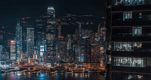 夜間香港天際線，閃爍的摩天大樓和港口倒影。 — 夜景城市 壁紙