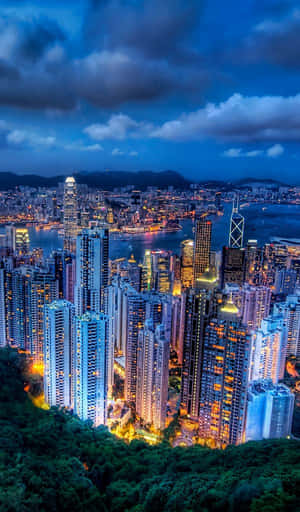 黃昏時分的香港城市景觀，燈火通明的建築物和港口 — Galaxy Tab A11 壁紙