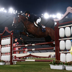 馬術運動員和馬在夜間體育場燈光下越過障礙物。 — 運動 壁紙