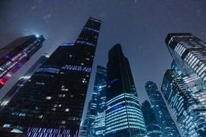 雪天下，燈火通明的摩天大樓夜景。 — 城市燈光 壁紙