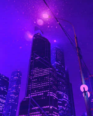 紫色霓虹燈照亮的夜間城市天際線，發光的摩天大樓和漂浮的粒子。 — 城市燈光 壁紙