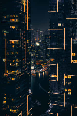 密集城市中水道周圍被照亮的摩天大樓的夜景。 — 小米平板 8 Pro 壁紙