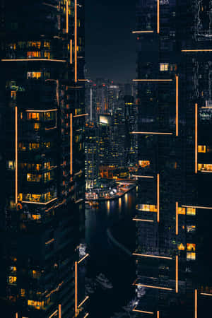 密集城市中水道周圍的摩天大樓夜景。 — Oppo Pad Mini 壁紙