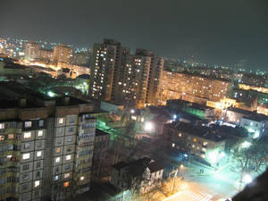 夜間城市景觀，有燈光照射的公寓大樓和街道。 — 城市風景 壁紙