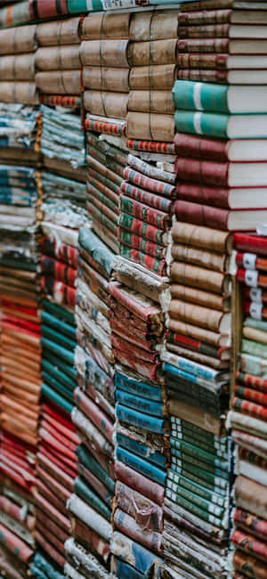 高高的復古書堆，彩色磨損的書脊。 — Pixel 8 壁紙