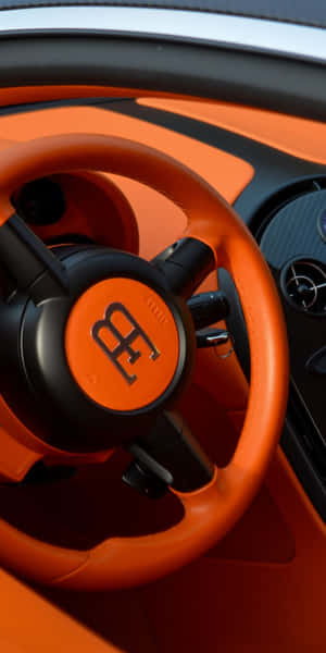 橙色Bugatti方向盤，帶有黑色飾邊及碳纖維儀表板。 — 汽車 壁紙
