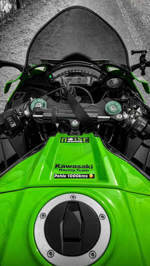 綠色Kawasaki賽車機車儀表板，帶有1000kms貼紙，位於碎石路上。 — 桌面 壁紙