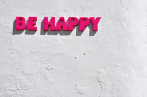 粉紅色3D字母寫著BE HAPPY，安裝在白色紋理牆上。 — 酷炫桌面 壁紙