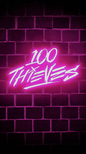 黑暗磚牆上寫著 100 THIEVES 的粉紅色霓虹燈招牌。 — 霓虹 壁紙