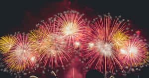 煙火在漆黑的夜空中爆發出紅色、黃色和白色。 — 新年快樂 2020 壁紙