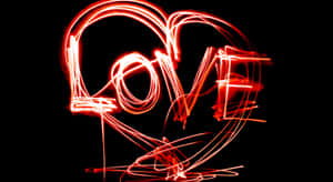 紅色光軌在黑色背景的心形內形成love一詞。 — 霓虹 壁紙