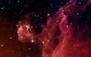 一個發光的紅色和藍綠色星雲，充滿了深空中的明亮星星。 — 宇宙 壁紙