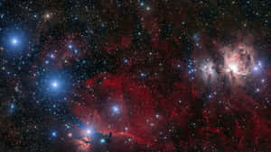 一個宇宙場景，有發光的紅色和藍色星雲以及無數星星。 — 暮光 壁紙
