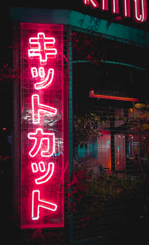 帶有日文文字的明亮紅色霓虹燈招牌在夜間城市環境中發光。 — Pixel Tablet 壁紙