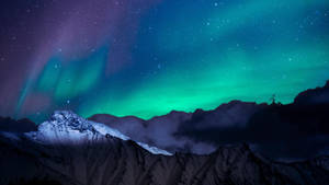北極光在星空下在白雪覆蓋的山上發光。 — 美麗的夜晚 壁紙