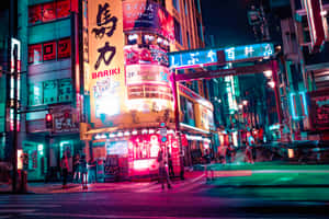 夜晚霓虹燈照亮東京街道，發光的招牌和模糊的車燈。 — 東京 壁紙